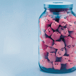 A glass jar filled with small plastic pigs.