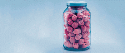 A glass jar filled with small plastic pigs.