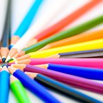 Sharp colorful pencils pointing toward each other.