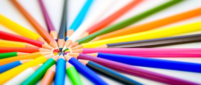 Sharp colorful pencils pointing toward each other.